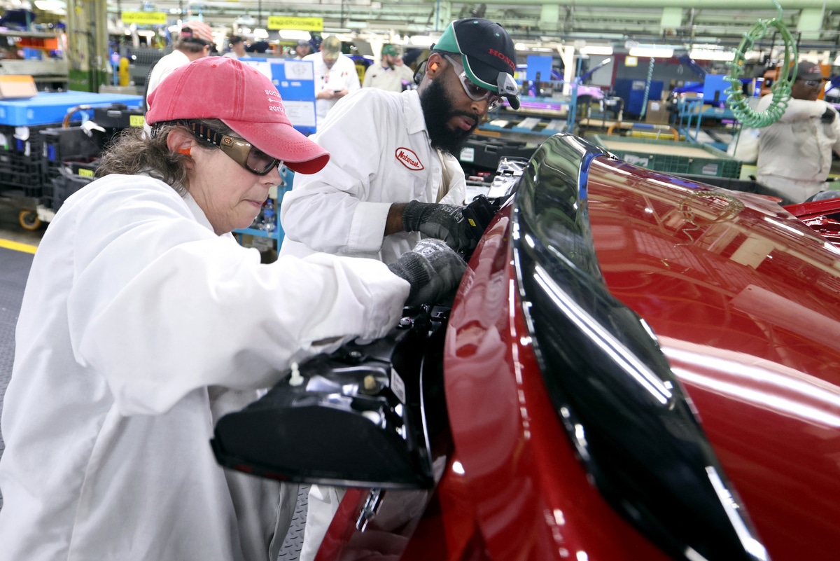 Honda associates install the rear combination lighting on the al