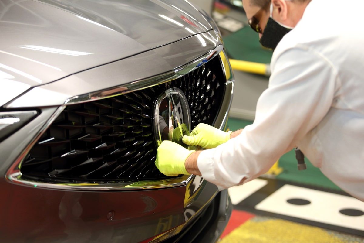 The Acura logo is carefully installed on a completed 2022 Acura Acura Images